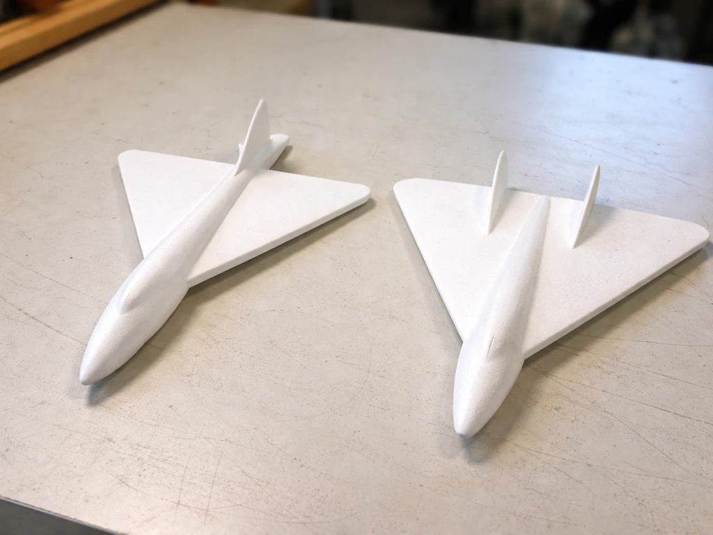 Two anonymous foam glider planes on a table, showing dart-body vs delta-wing shapes side by side.